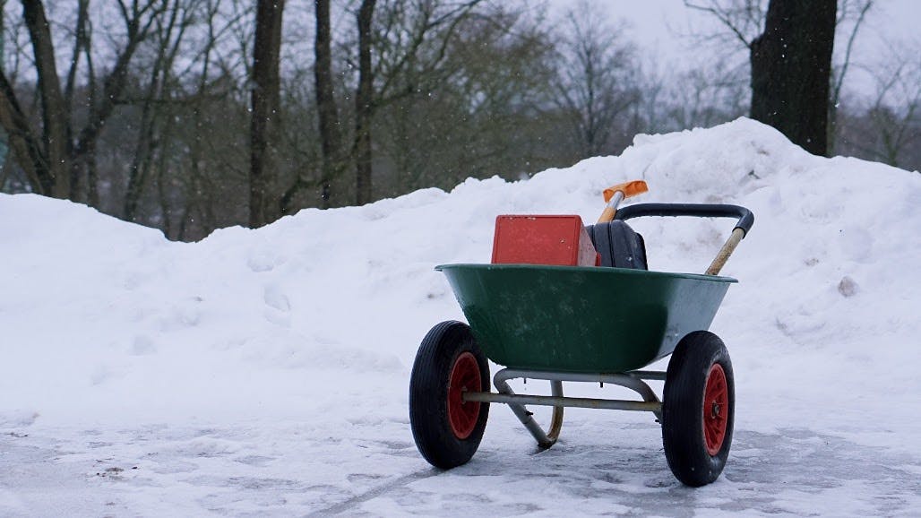 A wheelbarrow in front of a pile of snow near Kunsti Muuseum in Tallinn.