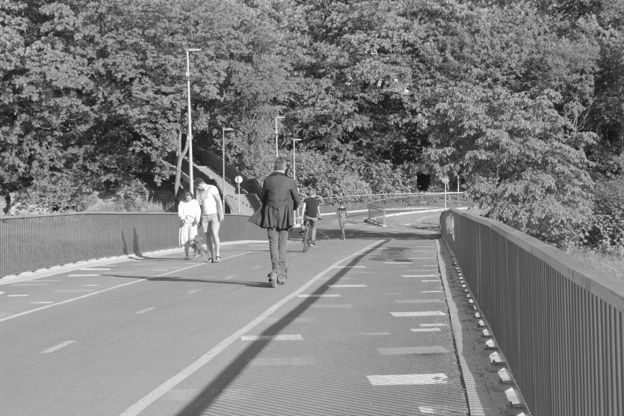 People are walking and riding on Ilvese bridge.